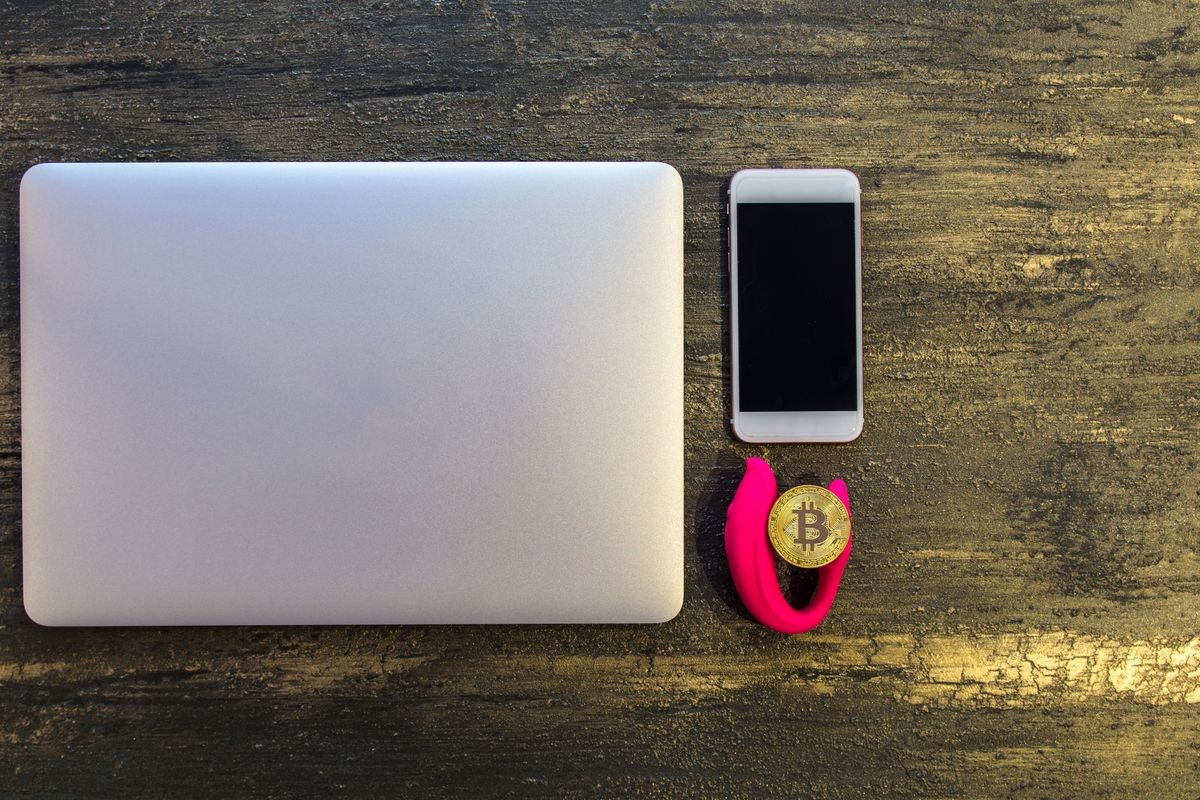 Top view of  table or desk with laptop bitcoin dildo and smartphone